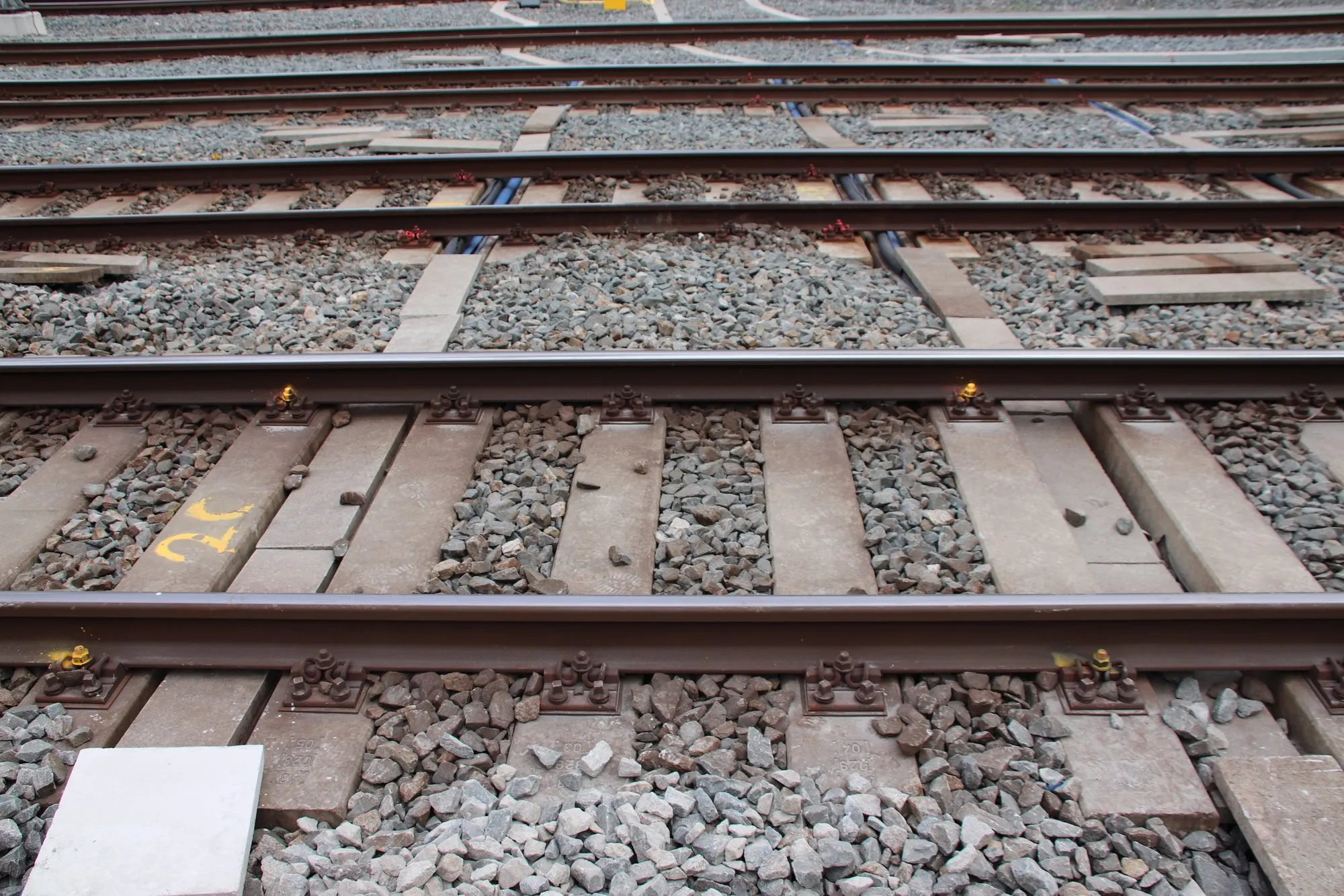 Cable ducts between the sleepers in a station area, with sleepers marked in yellow