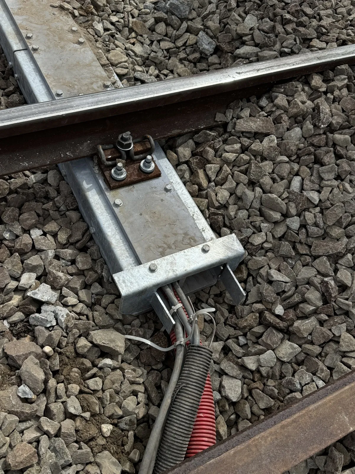 Cables leaving the hollow Kampa Sleeper into a flexible cable conduit on the ballast